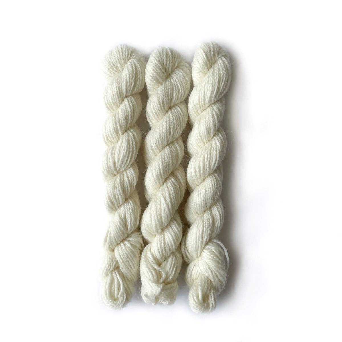 Kelbourne Woolens Perennial Minis yarn in soft white skeins, perfect for various knitting projects
