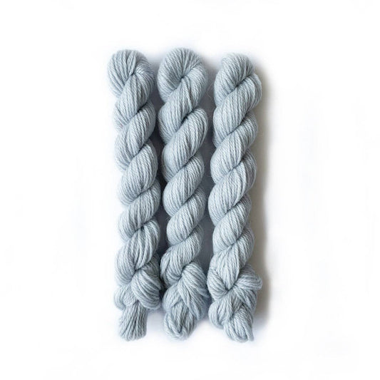 Three skeins of light blue Perennial Minis yarn from Kelbourne Woolens for knitting and crochet projects