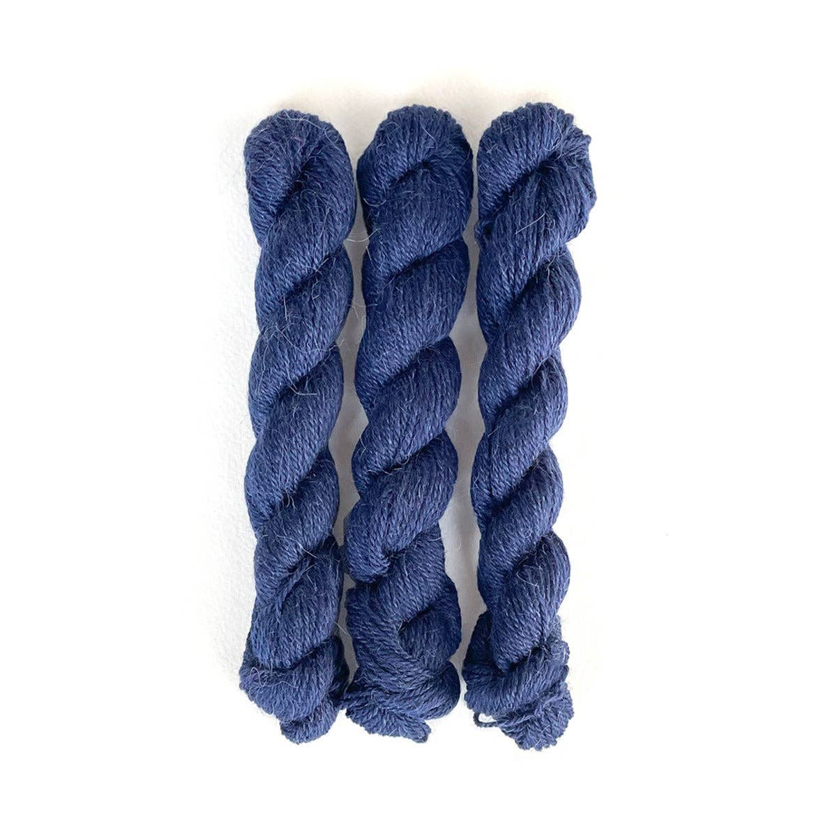 Three Skeins of Dark Blue Perennial Minis yarn by Kelbourne Woolens for knitting and crochet projects