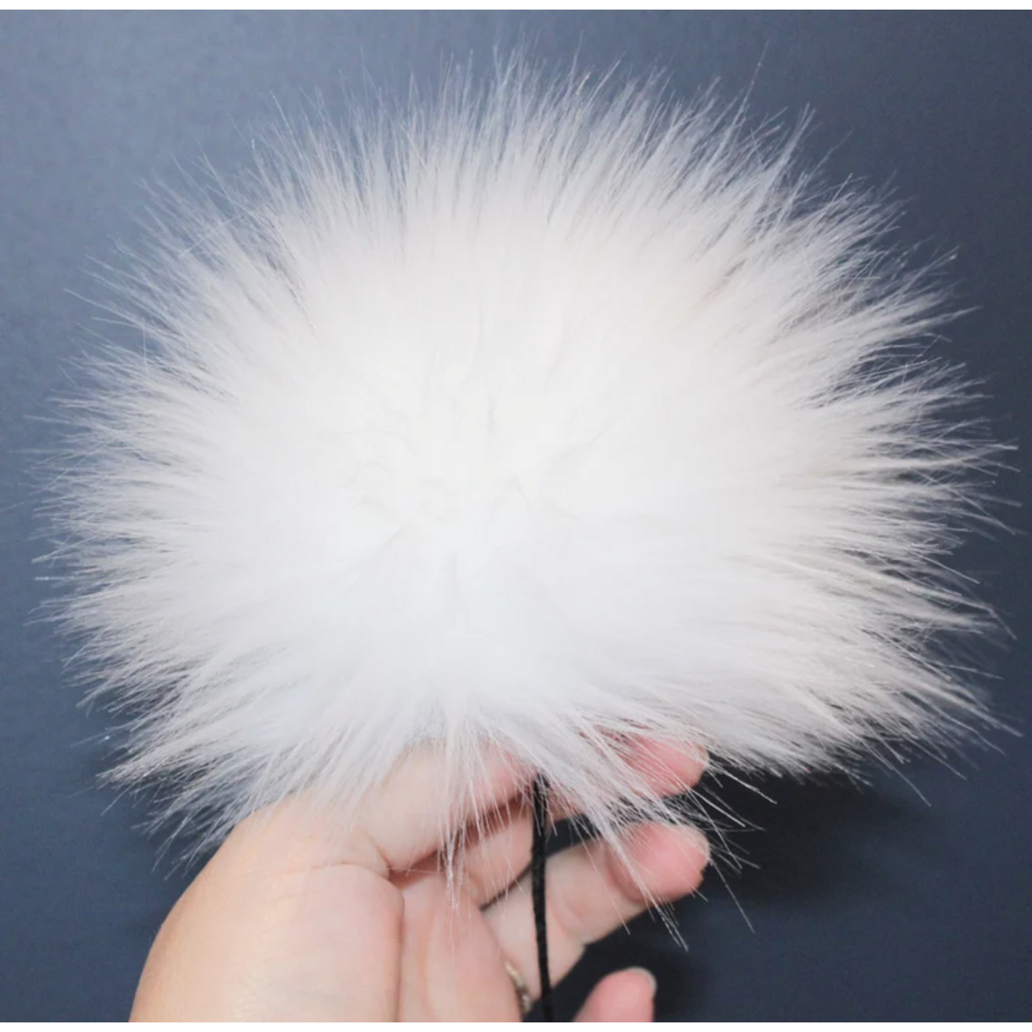 Fluffy white pom pom for knitting hats with attached string for easy attachment