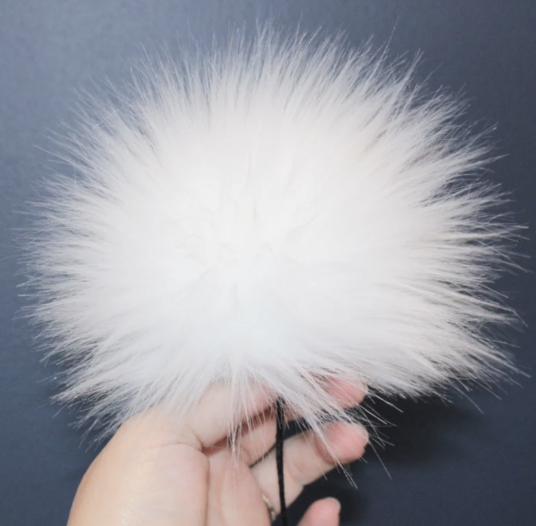 Fluffy white pom pom for knitting hats with attached string for easy attachment