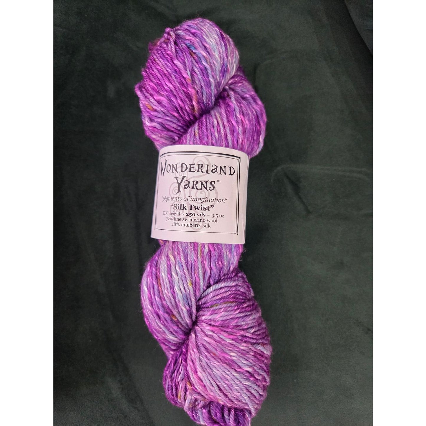Frabjous Fibers Wonderland Yarns Silk Twist hand dyed variegated purple and pink yarn skein on black background