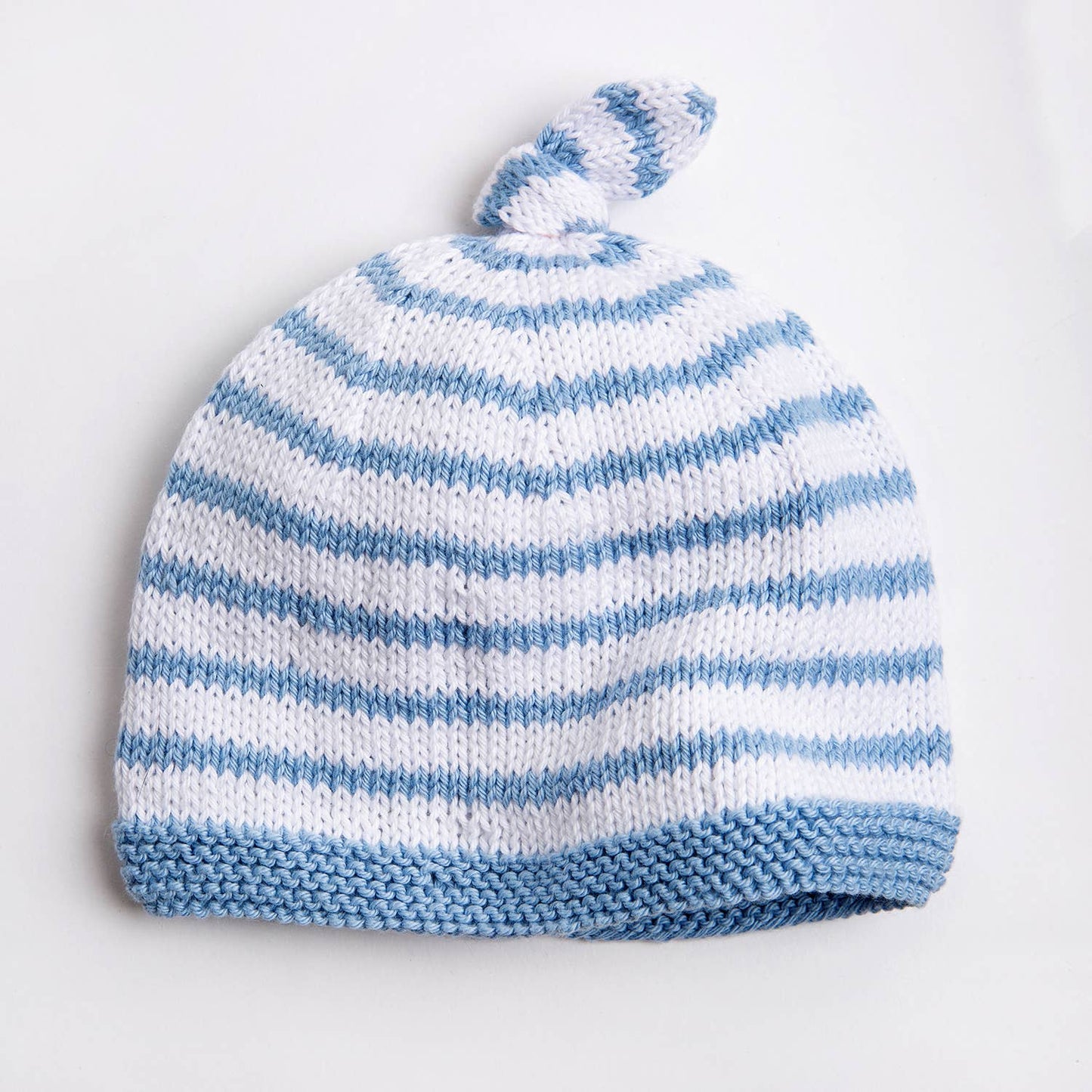 Wool Couture Company striped baby hat knitting pattern in white and blue with top knot and garter brim