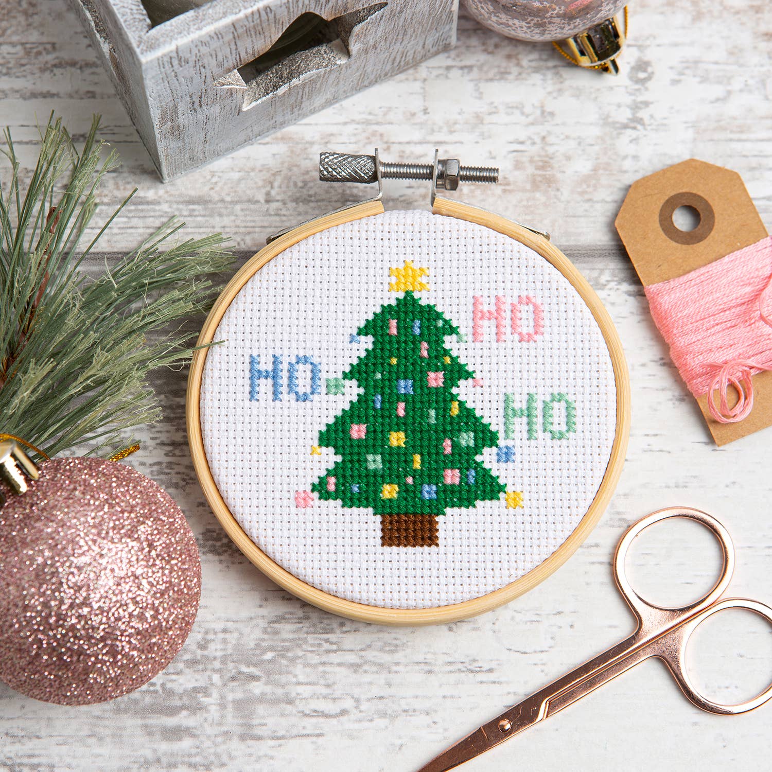 Wool Couture Company Christmas tree cross stitch kit embroidery hoop with stitched tree HO HO HO pink ornament and scissors