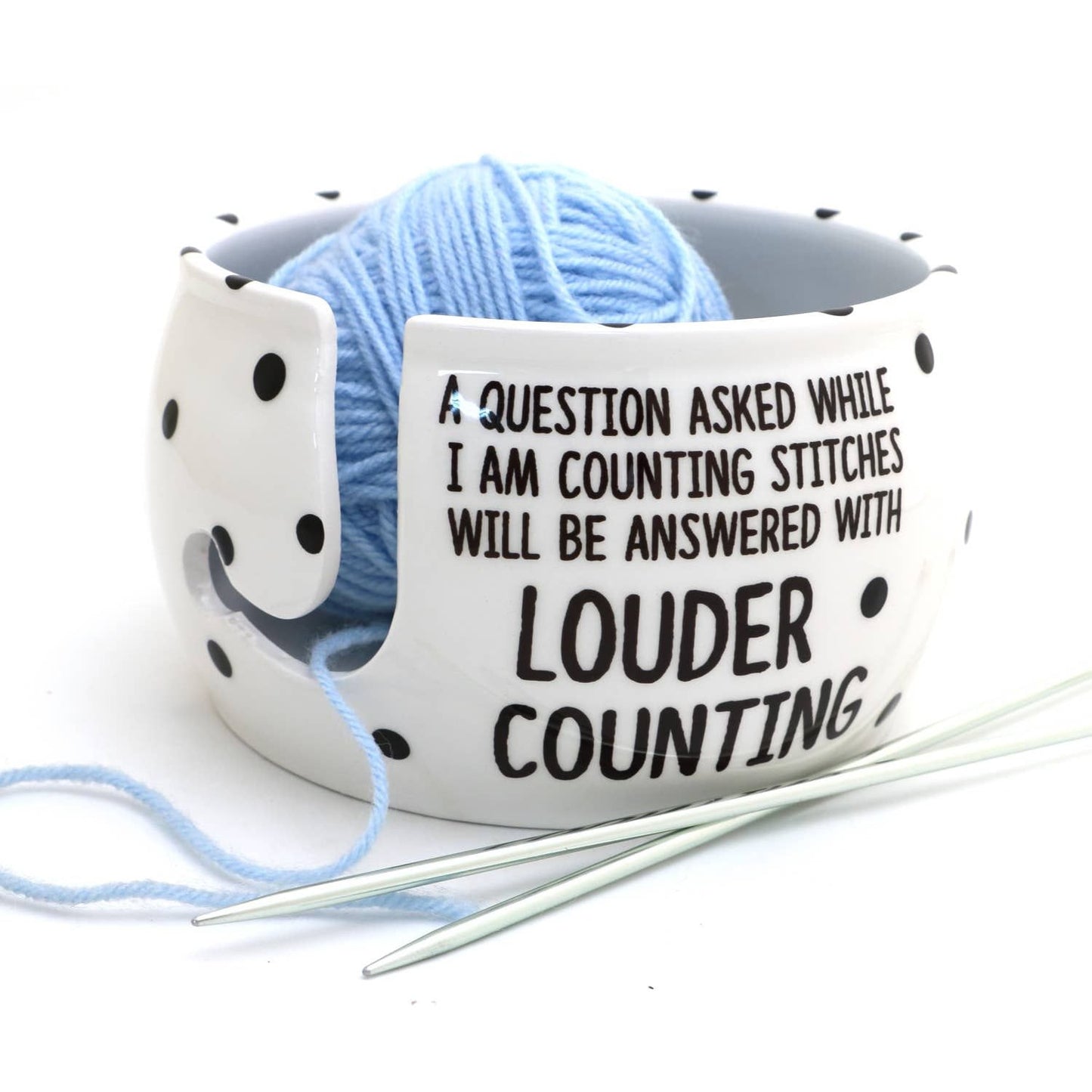 White ceramic yarn bowl for knitters with playful text and a blue yarn ball inside