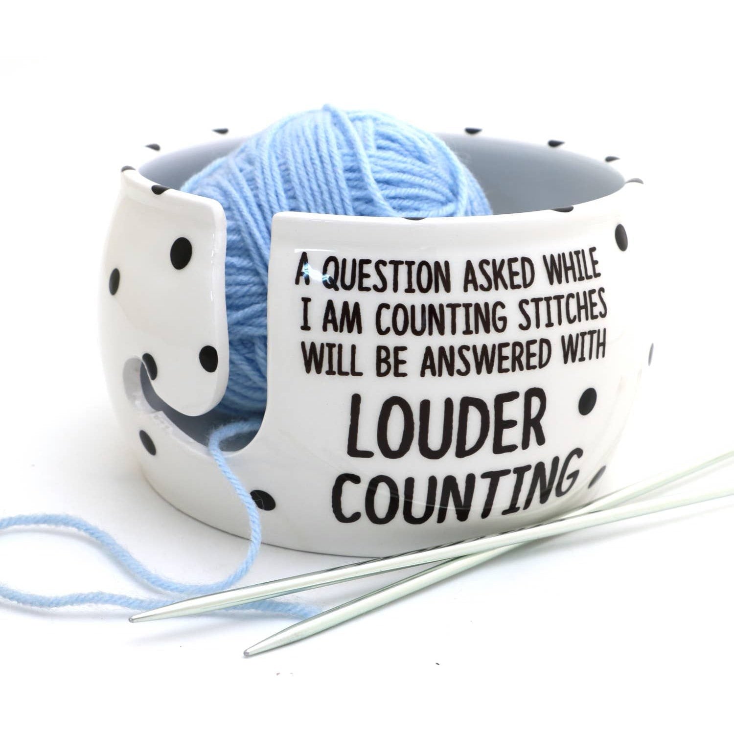 White ceramic yarn bowl for knitters with playful text and a blue yarn ball inside