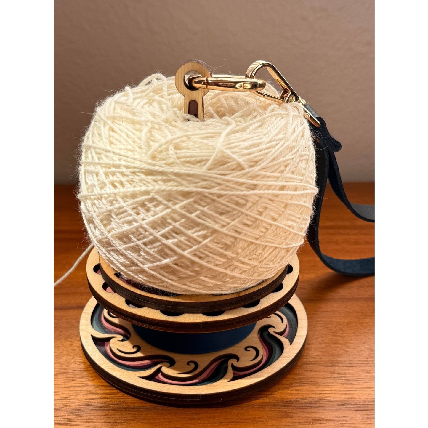 Lemonwood yarn winder holding cream-colored yarn ball with waves design base for crafters