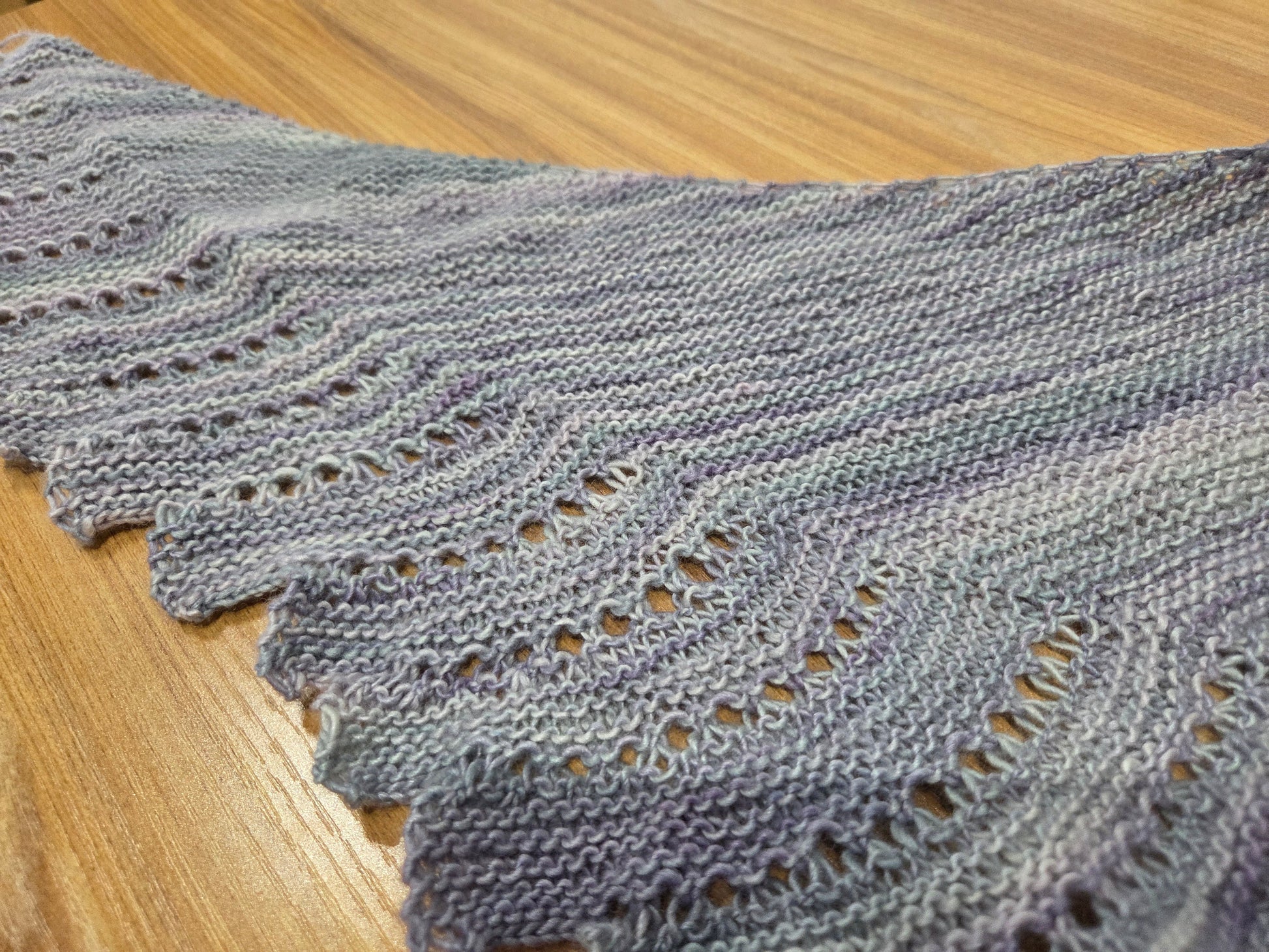 Hand knit lavender gray lace shawl sample on wood table for Close to You shawl class near Chicago at AriYARN Shop and Studio