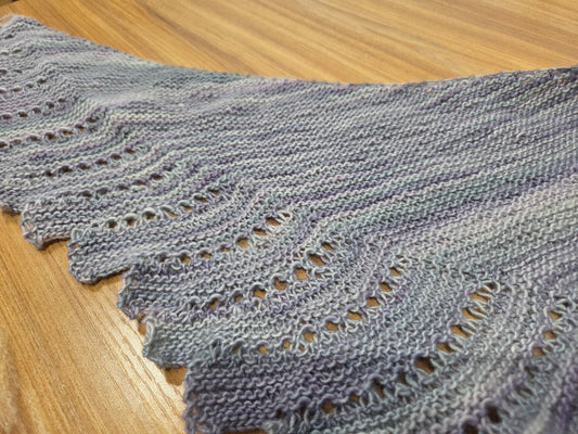 Hand knit lavender gray lace shawl sample on wood table for Close to You shawl class near Chicago at AriYARN Shop and Studio